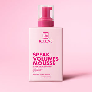 Bottle of 'Believe Speak Volumes Mousse' on a pink background